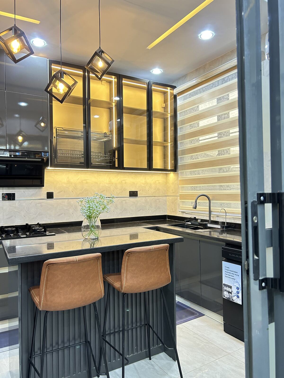 Kitchen with dark glass-front cabinets and pendant lighting