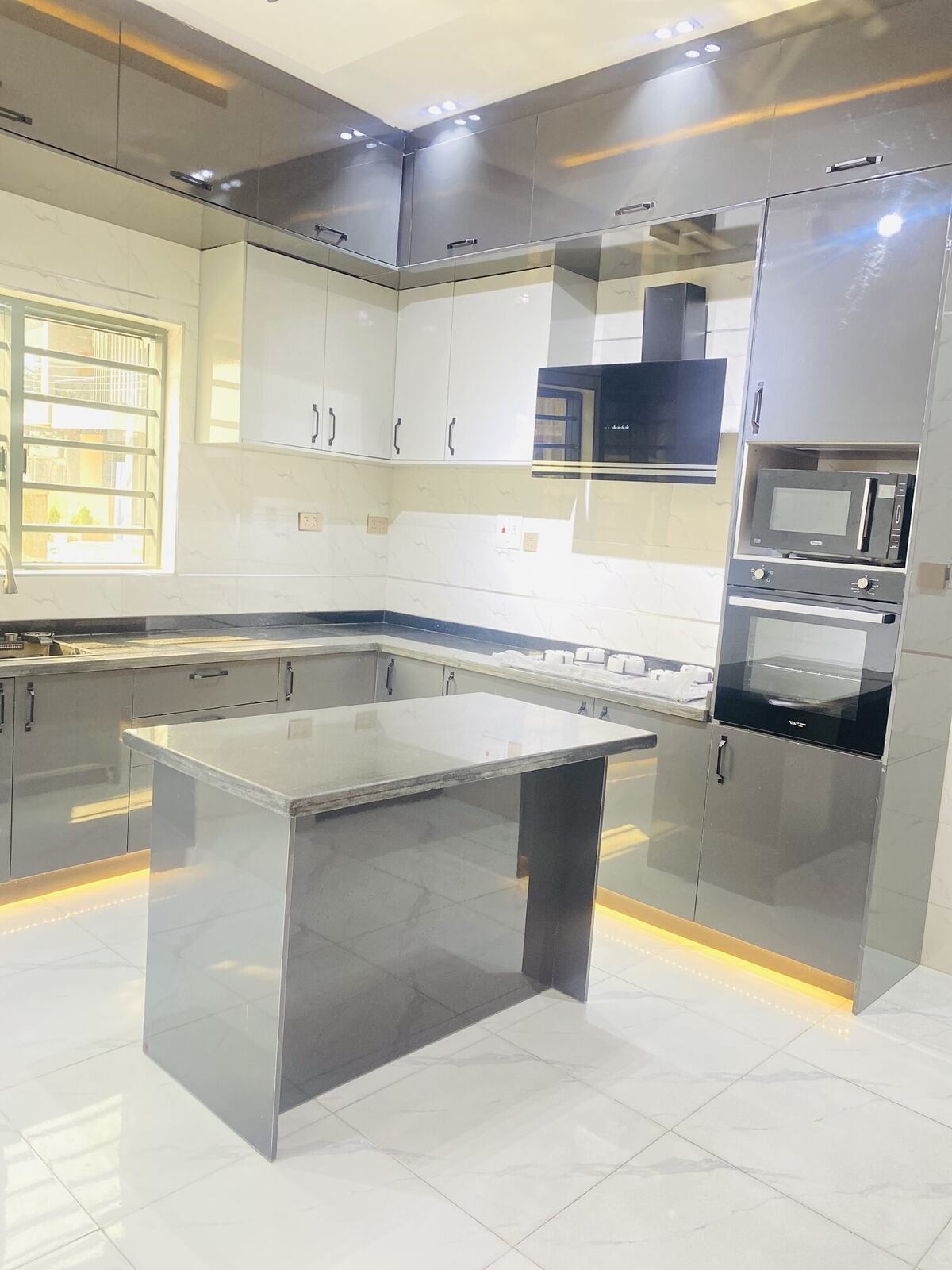 Kitchen with gray gloss cabinetry and island